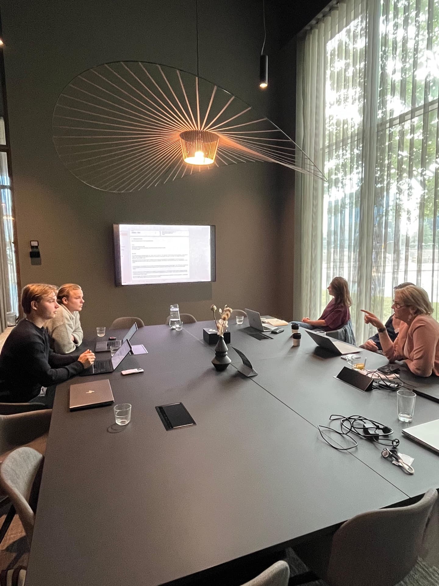 Around the table with the Varrlyn team, reviewing the work on the meeting-room screen